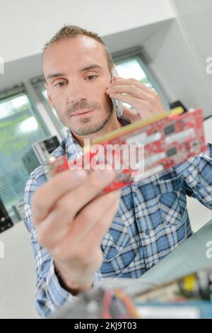 man looking at a chip while using the phone Stock Photo