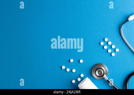 Composition of stethoscope and pills on blue background with copy space Stock Photo