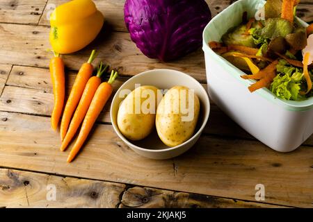 Raw vegetables and vegetable waste in kitchen composting bin Stock Photo