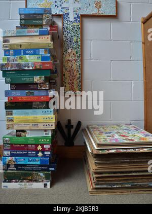 Stack Of Made Up Puzzles On Pieces Of Cardboard With The Puzzle Boxes Next To Them At United Reformed Church Jigsaw Puzzle Festival In Bitterne Stock Photo