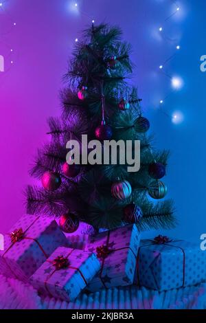 Gifts under the Christmas tree. Wrapped in wrapping paper and bows boxes. Golden, red balls, a garland on the Christmas tree. New Year 2023. Merry Christmas. Stock Photo