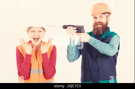 Husband annoying his wife. Man with happy face drills Stock Photo