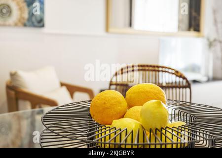 Decorative black wire centerpiece filled with ripe citrus in a contemporary decorated living room Stock Photo