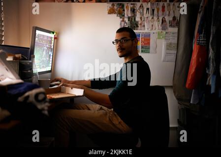 Working on a new game. a young programmer focused on his work. Stock Photo