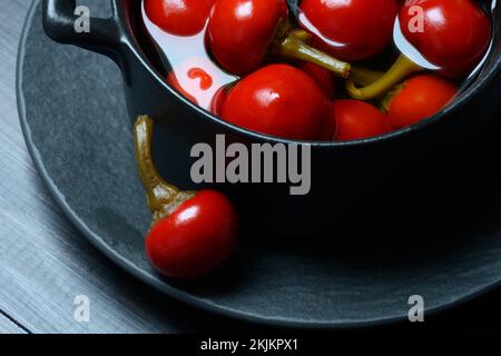 Potted cherry peppers in vinegar, chilli, paprika Stock Photo