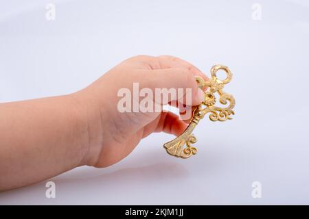 Child hand holding a retro styled decorative key Stock Photo