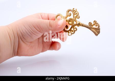 Child hand holding a retro styled decorative key Stock Photo