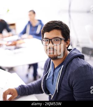 Failure is not an option when youre a programmer. Portrait of a young man sitting at his desk in an office. Stock Photo