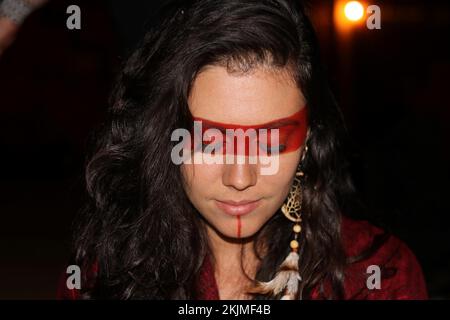Young woman, dark-haired with closed eyes and lowered gaze wearing traditional indigenous face paint and feather earring, Brazil, South America Stock Photo