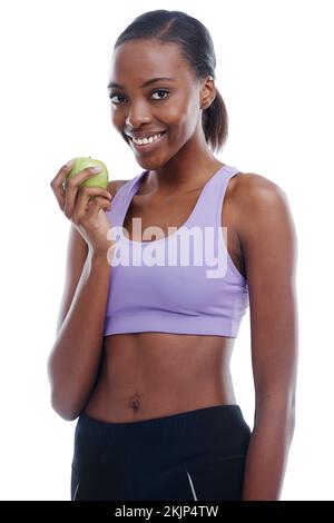 Healthy calories. An isolated portrait of a sporty young woman eating an apple. Stock Photo