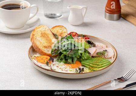 Fried eggs breakfast with salad and avocado Stock Photo