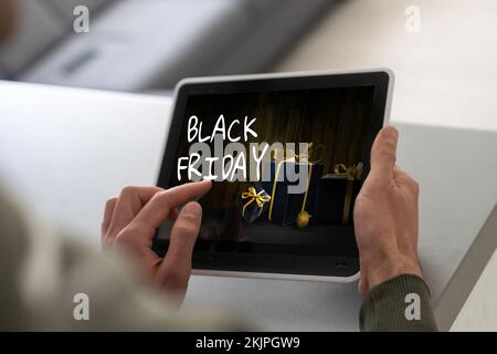 man using tablet pc and selecting black friday. Stock Photo