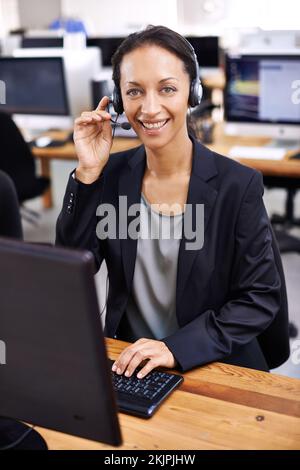 She handles her clients professionally. an attractive female call center representative wearing a headset. Stock Photo