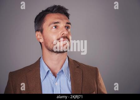 Looking ahead. Studio shot of a man deep in thought against a gray background. Stock Photo
