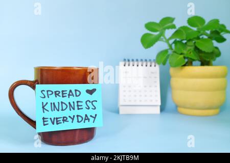 Spread kindness everyday and share blessings motivation and inspiration concept. Selective focus of a cup of coffee with handwritten bright paper note Stock Photo