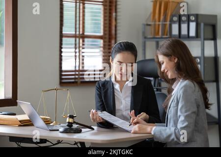 Female lawyer discuss to a legal document explaining the terms of a consultation with a businesswoman. before signing a contract with a law firm. Stock Photo