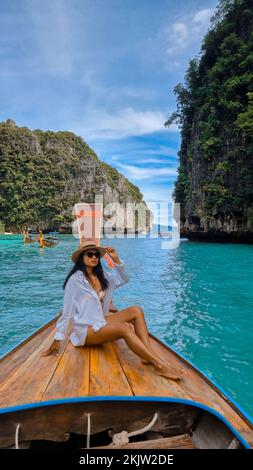 Asian Thai women in front of a Longtail boat at Pileh Lagoon Koh Phi Phi Thailand. Stock Photo