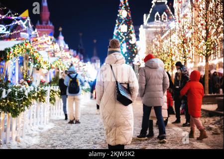 Moscow, Russia - January 7, 2022: Girl walks near GUM on Red Square near the Kremlin. New Year decorations and Christmas atmosphere on a winter street Stock Photo