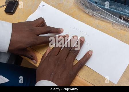 Close-up of a blind person reading Braille script printout Stock Photo