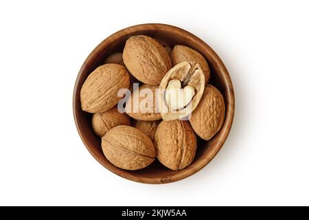 Shelled walnuts with half heart shaped walnut in wooden bowl on white background Stock Photo