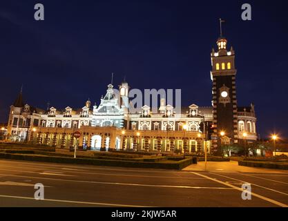 Dunedin's famous historic railway station at nightime. - Dunedin New Zealand. This ornate Flemish Renaissance-style building was opened in 1906 and is Stock Photo