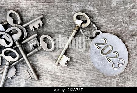 2023 engraved on a ring of an old key on wooden background Stock Photo