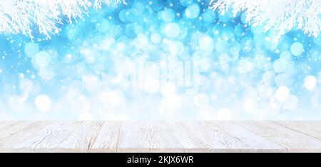 Old white vintage planked wood table in perspective on bright blue bokeh winter background with white snowy branches and falling snow. Product display Stock Photo