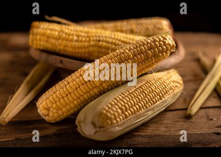 Several ears of corn Zea mays on rustic wooden table Stock Photo