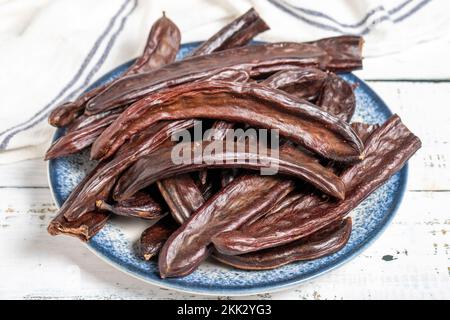 Carob on wood background. Healthy food. close up Stock Photo