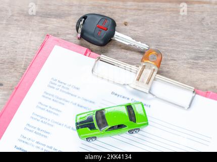 Green toy car and key, concept in insurance,loan,finance and buying car background Stock Photo