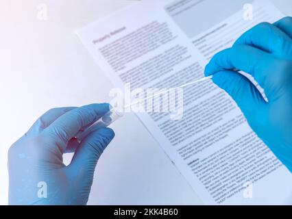 Close up of a doctor using coronavirus covid-19 rapid antigen home testing kit on blur background. Stock Photo
