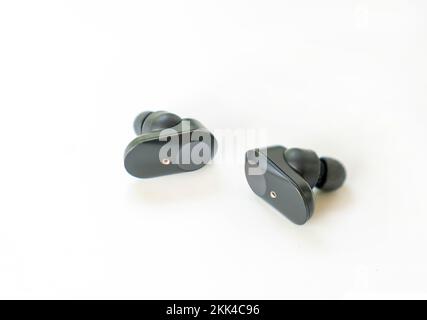 Pair of black true wireless earphone isolate on white badckground. Technology bluetooth connect. Stock Photo