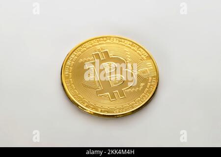 Golden physical Bitcoin on white background. Digital currency, cryptocurrency, blockchain technology concept. Stock Photo