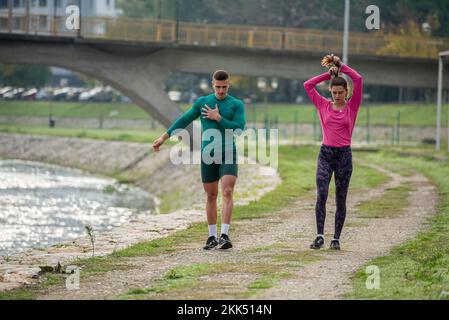 Attractive and strong friends are taking a break from running while walking and talking Stock Photo