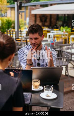 Beautiful business couple are smiling and having a good time at cafe bar, on a sunny day Stock Photo