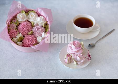 tea set in a composition with marshmallow flowers. Coffee mug on a saucer. on a light gray background. morning invigorating tea party Stock Photo