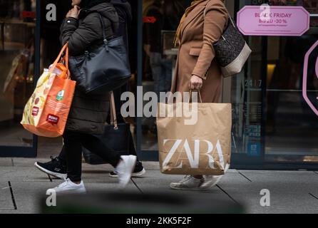 Frankfurt, Germany. 25th Nov, 2022. 25 November 2022, Hessen, Frankfurt/Main: Women walk down the Zeil, Frankfurt's central shopping street, with full shopping bags. Every year on the fourth Friday in November, countless retailers and online stores reduce their prices for at least 24 hours and sometimes outbid each other with discounts and special offers. Photo: Frank Rumpenhorst/dpa Credit: dpa picture alliance/Alamy Live News Stock Photo