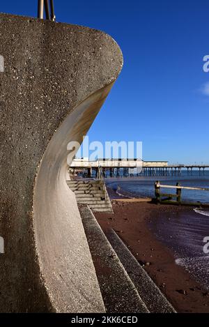 The pier and part of the seawall at Teignmouth, showing the curved returns that deflect the waves. Stock Photo