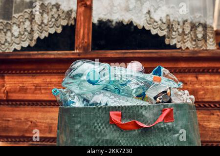 Plastic bottles collected in big container. Heap of plastic bottles, cups, bags collected to recycling. Concept of plastic pollution and too many plas Stock Photo