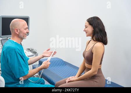 Doctor is instructing a woman before an ultrasound procedure Stock Photo