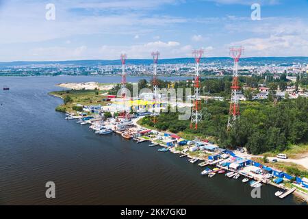 High-voltage power line truss poles mounted on the Varna lake shore. Landscape photo taken from Asparuhov Bridge, Varna, Bulgaria Stock Photo