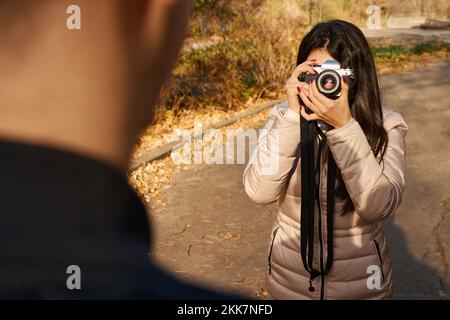 Long-haired woman holds a camera to her face Stock Photo