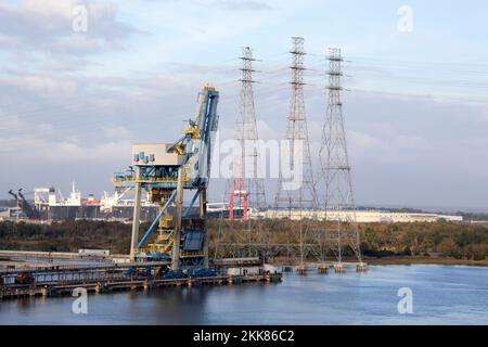 The crane and three electrical towers by St. Johns River in Jacksonville city port (Florida). Stock Photo