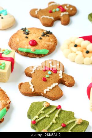 Gingerbread Man with Assortment of Christmas Cookies Scattered on a White Background Stock Photo