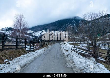 Carpathian, Romania, 2021-12-28. Mud road mixed with snow. Stock Photo