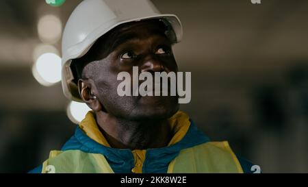 Close-up serious focused mature man professional civil engineer in protective helmet inspects develops plan businessman builder experienced Stock Photo