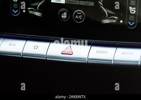 Red triangle hazard light button on car dashboard. Car media buttons dashboard. Detail of a modern car controllers. Stock Photo