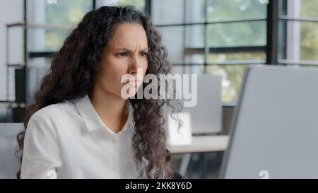 Frustrated woman reading bad news on computer excited businesswoman feeling stressed due to loss of important data file error mistake upset worried Stock Photo