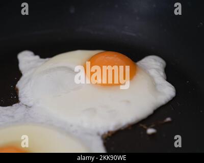 Two fried eggs in a frying pan. Close up. Stock Photo