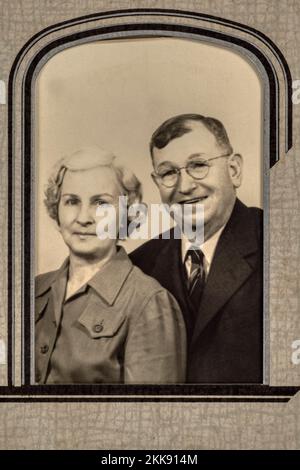 Long deceased grandparents of photographer    Antique black and white 1940’s portrait of a happy elderly couple in cardboard framing mat. Stock Photo